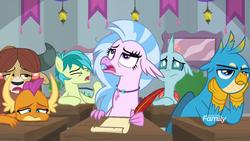 Size: 1600x900 | Tagged: safe, screencap, gallus, ocellus, sandbar, silverstream, smolder, yona, changedling, changeling, classical hippogriff, dragon, earth pony, griffon, hippogriff, pony, yak, g4, school daze, bored, braid, classroom, claws, curved horn, desk, discovery family, discovery family logo, dragoness, eyeroll, eyes closed, female, folded wings, frown, hands on cheeks, head feathers, head on table, horn, horns, jewelry, logo, looking up, male, narrowed eyes, necklace, open mouth, quill pen, stallion, student six, talons, teenaged dragon, teenager, wings, yawn