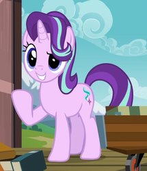 Size: 666x774 | Tagged: safe, screencap, starlight glimmer, pony, unicorn, g4, uncommon bond, blue eyes, book, cart, cloud, cropped, cute, cutie mark, female, glimmerbetes, grin, hair over one eye, horn, mare, mountain, raised eyebrow, raised hoof, smiling, solo, train station, wheel