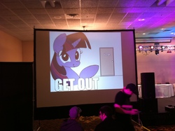 Size: 2592x1936 | Tagged: safe, artist:zev, twilight sparkle, pony, unicorn, g4, convention, convention:mlp-msp, cute, door, exit, faic, female, get out, irl, looking at you, mare, mlp-msp, photo, pointing, reaction image, screen, smiling, smirk, twiface, wrong neighborhood