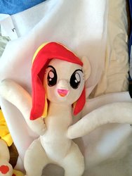 Size: 768x1024 | Tagged: safe, artist:nekokevin, oc, oc:poniko, earth pony, pony, female, irl, looking at you, lying down, mare, open mouth, photo, plushie, raised hoof, smiling, solo
