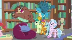Size: 1920x1080 | Tagged: safe, screencap, gallus, ocellus, sandbar, silverstream, smolder, yona, changedling, changeling, classical hippogriff, dragon, earth pony, griffon, hippogriff, pony, yak, g4, what lies beneath, amused, bookshelf, bow, cloven hooves, cup, discovery family, discovery family logo, dragoness, female, flower, flying, hair bow, jewelry, library, logo, male, monkey swings, necklace, panic, screaming, scroll, smiling, smirk, student six, teacup, teenager