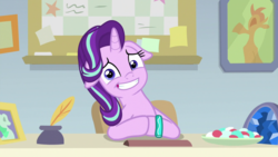 Size: 1920x1080 | Tagged: safe, screencap, starlight glimmer, pony, unicorn, student counsel, awkward smile, bracelet, cute, female, floppy ears, food, geode, glimmerbetes, inkwell, jewelry, looking at you, mare, photo, quill, sitting, smiling, solo, starlight's office