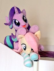 Size: 768x1024 | Tagged: safe, artist:nekokevin, fluttershy, starlight glimmer, pegasus, pony, unicorn, series:nekokevin's glimmy, g4, clothes, duo, female, irl, lying down, mare, on top, open mouth, photo, plushie, smiling, socks, striped socks, underhoof