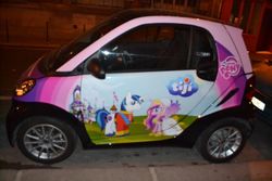 Size: 900x600 | Tagged: safe, princess cadance, shining armor, alicorn, pony, g4, car, channel, female, irl, male, mare, my little pony logo, night, photo, smart (car), smart fortwo, stallion, tiji