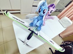 Size: 1024x760 | Tagged: safe, artist:nekokevin, starlight glimmer, trixie, pony, unicorn, series:nekokevin's glimmy, g4, duo, female, irl, looking at you, mare, open mouth, photo, plane, plushie, raised hoof, rc plane, sitting, smiling, table, underhoof