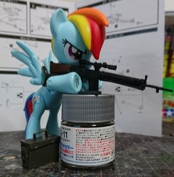Size: 2160x2206 | Tagged: safe, artist:omegapony16, rainbow dash, pegasus, pony, g4, female, goggles, grin, gun, high res, irl, mare, photo, rifle, smiling, solo, toy, underhoof, weapon