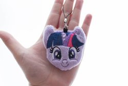Size: 1000x670 | Tagged: safe, artist:meplushyou, twilight sparkle, human, pony, g4, charm, female, hand, irl, irl human, looking at you, mare, photo, plushie, smiling