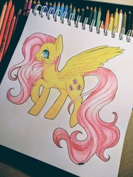 Size: 3120x4160 | Tagged: safe, artist:hikarinohibana, fluttershy, pegasus, pony, g4, blushing, colored pencil drawing, female, mare, pencil, photo, profile, raised hoof, raised leg, sketchpad, smiling, solo, spread wings, standing, traditional art, wings