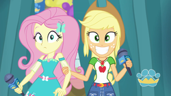 Size: 1920x1080 | Tagged: safe, screencap, applejack, fluttershy, best in show: the pre-show, equestria girls, g4, my little pony equestria girls: better together, female, geode of fauna, geode of super strength, grin, magical geodes, microphone, smiling