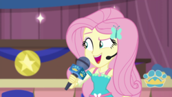 Size: 1280x720 | Tagged: safe, screencap, fluttershy, best in show: the victory lap, equestria girls, g4, my little pony equestria girls: better together, best in show logo, female, geode of fauna, magical geodes, microphone, open mouth, smiling, solo