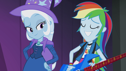 Size: 1920x1080 | Tagged: safe, screencap, rainbow dash, trixie, equestria girls, g4, my little pony equestria girls: rainbow rocks, cape, clothes, female, guitar, hand on hip, hat, smiling, trixie's cape, trixie's hat