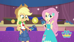 Size: 1920x1080 | Tagged: safe, screencap, applejack, fluttershy, best in show: the victory lap, equestria girls, g4, my little pony equestria girls: better together, applejack's hat, applejack's skirt, belt, clothes, collar, cowboy hat, denim skirt, dress, female, freckles, geode of fauna, geode of super strength, hair, hat, looking at self, looking down, magical geodes, microphone, playing with hair, ponytail, shirt, skirt, t-shirt, teenager