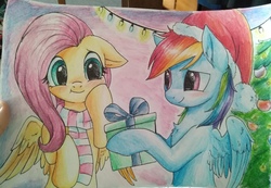 Size: 2560x1768 | Tagged: safe, artist:megabait, fluttershy, rainbow dash, pony, g4, blushing, christmas, christmas lights, christmas tree, clothes, female, gift giving, hat, hearth's warming, holiday, hoof hold, lesbian, present, santa hat, scarf, ship:flutterdash, shipping, smiling, traditional art, tree