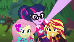 Size: 1280x720 | Tagged: safe, screencap, fluttershy, sci-twi, sunset shimmer, twilight sparkle, equestria girls, equestria girls series, festival filters, g4, spoiler:eqg series (season 2), bigfoot, bigfoot blurry in the background, female, geode of telekinesis, magical geodes, peace sign, sasquatch, selfie, smiling