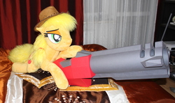 Size: 1980x1174 | Tagged: safe, artist:ponimalion, applejack, earth pony, pony, g4, badass, bed, bedroom eyes, female, freckles, hat, irl, life size, lying, mare, photo, plushie, quake 3 arena, rocket launcher, weapon