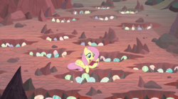 Size: 2100x1180 | Tagged: safe, screencap, fluttershy, pegasus, pony, g4, sweet and smoky, book, dragon egg, dragon lands, egg, female, mare, nest, prone