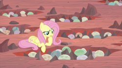 Size: 2100x1180 | Tagged: safe, screencap, fluttershy, pegasus, pony, g4, sweet and smoky, dragon egg, dragon lands, female, hoof on chin, mare, nest, prone, solo