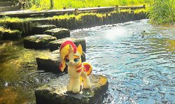 Size: 2048x1224 | Tagged: safe, artist:hihin1993, sunset shimmer, pony, unicorn, g4, female, irl, japan, lidded eyes, looking at you, mare, photo, plushie, smiling, smug, smugset shimmer, solo, stepping stones, water