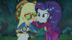 Size: 1280x720 | Tagged: safe, screencap, applejack, rarity, equestria girls, equestria girls series, g4, inclement leather, my little pony equestria girls: choose your own ending, spoiler:eqg series (season 2), cheek to cheek, clothes, dress, freckles, hand on face, inclement leather: applejack, jacket, mud, outdoors, rain, shipping fuel, smiling, squishy cheeks, sunglasses, wet