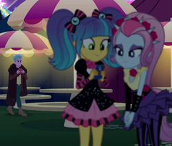 Size: 1020x866 | Tagged: safe, screencap, pixel pizazz, violet blurr, equestria girls, equestria girls specials, g4, my little pony equestria girls: better together, my little pony equestria girls: sunset's backstage pass, cellphone, clothes, cool scarf guy, cropped, female, male, miniskirt, outdoors, pantyhose, phone, picnic table, pigtails, skirt, smartphone, spiked headband, table, the snapshots, twintails, umbrella, unnamed character, unnamed human