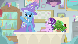 Size: 1920x1080 | Tagged: safe, screencap, phyllis, starlight glimmer, trixie, pony, unicorn, a horse shoe-in, g4, cape, clothes, duo, female, hat, mare, potted plant, raised hoof, table, trixie's cape, trixie's hat