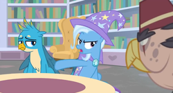Size: 1600x862 | Tagged: safe, screencap, gallus, grampa gruff, trixie, griffon, pony, unicorn, a horse shoe-in, g4, blind eye, book, cape, chair, clothes, female, fez, hat, library, male, mare, pouting, sad, table, trio, trixie's cape, trixie's hat, unamused, upset