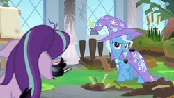 Size: 1600x900 | Tagged: safe, screencap, starlight glimmer, trixie, pony, a horse shoe-in, g4, bog, burnt, cape, cattails, clothes, column, dirt, easel, grass, hat, inkwell, leaves, mess, moss, quill, reeds, singed, trixie's cape, trixie's hat, window