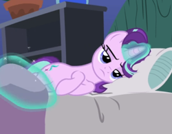 Size: 582x455 | Tagged: safe, screencap, starlight glimmer, pony, unicorn, g4, rock solid friendship, bed, blanket, cropped, female, glowing horn, horn, levitation, lidded eyes, lying down, magic, mare, pillow, solo, starlight glimmer is not amused, telekinesis, unamused