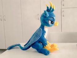 Size: 1024x768 | Tagged: safe, artist:nekokevin, gallus, griffon, g4, folded wings, irl, lidded eyes, male, photo, plushie, side view, sitting, smiling, solo, teenager, wings