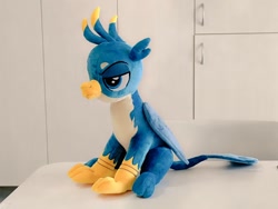 Size: 1024x768 | Tagged: safe, artist:nekokevin, gallus, griffon, g4, irl, lidded eyes, male, photo, plushie, side view, sitting, smiling, solo, teenager