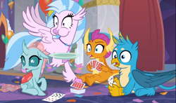 Size: 1460x857 | Tagged: safe, screencap, gallus, ocellus, silverstream, smolder, changedling, changeling, classical hippogriff, dragon, griffon, hippogriff, g4, she's all yak, aweeg*, cropped, cute, deck of cards, diaocelles, diastreamies, female, flying, gallabetes, group, juxtaposition bait, male, open mouth, plate, playing card, prone, puffy cheeks, shocked, shrunken pupils, sitting, smolderbetes, spread wings, wings