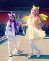 Size: 1080x1350 | Tagged: safe, fluttershy, rarity, human, g4, clothes, cosplay, costume, curtsey, cutie mark, cutie mark on clothes, dress, female, horn, irl, irl human, photo, shoes, wings