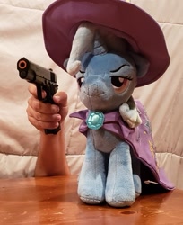 Size: 521x637 | Tagged: safe, trixie, pony, unicorn, g4, 1911, delet this, female, gun, hand, irl, lidded eyes, mare, photo, plushie, smiling, smirk, solo, toy, wat, weapon