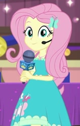 Size: 384x609 | Tagged: safe, screencap, fluttershy, best in show: the victory lap, equestria girls, g4, my little pony equestria girls: better together, beautiful, best in show logo, clothes, cute, cutie mark, cutie mark on clothes, dress, dress interior, female, fluttershy boho dress, geode of fauna, headworn microphone, looking at you, magical geodes, microphone, shyabetes, smiling, smiling at you
