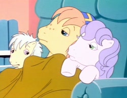 Size: 1402x1080 | Tagged: safe, screencap, amber (g1), rusty, twink (g1), earth pony, pony, g1, my little pony tales, too sick to notice, baseball cap, big brother, blanket, blue eyes, cap, chair, colt, cuddling, female, filly, foal, freckles, green eyes, hat, huddle, little brother, little sister, male, pink eyes, purple hair, recliner, siblings, sick, under blanket, white hair, yellow coat