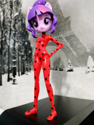 Size: 3472x4624 | Tagged: safe, sci-twi, twilight sparkle, human, equestria girls, g4, absurd resolution, becoming what you fear, bodysuit, customized toy, doll, eiffel tower, equestria girls minis, female, grayscale background, hand on hip, irl, marinette dupain-cheng, miraculous ladybug, photo, smiling, solo, toy