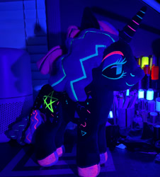 Size: 1280x1419 | Tagged: safe, artist:orky, oc, oc only, oc:twinkle pop, pony, unicorn, black sclera, commission, glow in the dark, horn, indoors, irl, photo, plushie, pony plushie, smiling, solo, table, unicorn oc, uv light