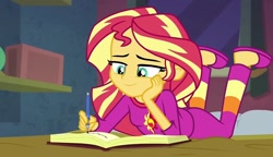 Size: 1250x720 | Tagged: safe, screencap, sunset shimmer, equestria girls, g4, book, clothes, female, happy, pajamas, smiling, solo, writing