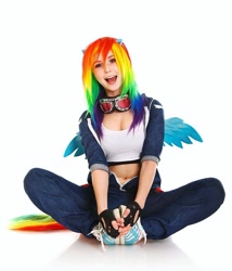 Size: 1080x1260 | Tagged: safe, artist:natsumipon, rainbow dash, human, g4, belly button, clothes, cosplay, costume, fingerless gloves, gloves, irl, irl human, open mouth, open smile, photo, shoes, simple background, sitting, smiling, sneakers, white background