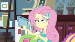 Size: 1920x1078 | Tagged: safe, screencap, fluttershy, blizzard or bust, equestria girls, equestria girls series, g4, holidays unwrapped, spoiler:eqg series (season 2), backpack, bags under eyes, bedroom, book, exhausted, female, geode of fauna, magical geodes, sci-twi's room, solo