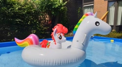 Size: 2048x1130 | Tagged: safe, artist:steam-loco, oc, oc:stroopwafeltje, pony, unicorn, brick wall, floaty, holland, horn, inflatable unicorn, inflation valve, irl, netherlands, opaque inflatable, outdoors, photo, plushie, ponycon holland, self ponidox, swimming pool, unicorn oc, water, window