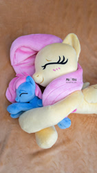 Size: 1152x2048 | Tagged: safe, artist:meplushyou, fluttershy, oc, pony, g4, baby, baby pony, cuddling, irl, photo, plushie