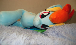 Size: 3008x1790 | Tagged: safe, artist:lanacraft, rainbow dash, pegasus, pony, g4, bed, female, irl, looking at you, lying down, mare, photo, plushie, smiling, smiling at you