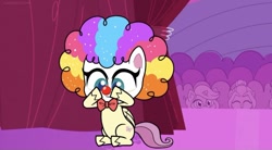 Size: 828x457 | Tagged: safe, screencap, fluttershy, pegasus, pony, g4.5, lolly-pop, my little pony: pony life, spoiler:pony life s02e19, backstage, bowtie, clown, clown makeup, clown nose, clown wig, crowd, curtains, cute, female, flutterclown, logo, red nose, shyabetes, sitting, solo