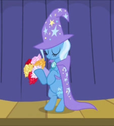Size: 652x720 | Tagged: safe, screencap, trixie, pony, unicorn, boast busters, g4, season 1, bipedal, bouquet, brooch, cape, clothes, cropped, curtains, eyes closed, flower, hat, jewelry, smiling, solo, stage, stars, trixie's brooch, trixie's cape, trixie's hat