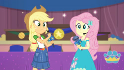 Size: 3410x1920 | Tagged: safe, screencap, applejack, fluttershy, best in show: the victory lap, equestria girls, equestria girls series, g4, spoiler:eqg series (season 2), applejack's hat, belt, best in show logo, clothes, cowboy hat, cutie mark, cutie mark on clothes, denim skirt, female, geode of fauna, geode of super strength, hairpin, hat, jewelry, magical geodes, microphone, necklace, skirt, smiling