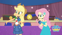 Size: 3410x1920 | Tagged: safe, screencap, applejack, fluttershy, best in show: the victory lap, equestria girls, equestria girls series, g4, spoiler:eqg series (season 2), applejack's hat, belt, best in show logo, clothes, cowboy hat, cutie mark, cutie mark on clothes, denim skirt, female, geode of fauna, geode of super strength, hairpin, hand on hip, hat, jewelry, magical geodes, microphone, necklace, open mouth, skirt, smiling