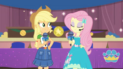 Size: 3410x1920 | Tagged: safe, screencap, applejack, fluttershy, best in show: the victory lap, equestria girls, equestria girls series, g4, spoiler:eqg series (season 2), applejack's hat, best in show logo, clothes, cowboy hat, cutie mark, cutie mark on clothes, eyes closed, female, geode of super strength, hairpin, hand on hip, hat, jewelry, lip bite, magical geodes, microphone, necklace, smiling