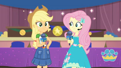 Size: 3410x1920 | Tagged: safe, screencap, applejack, fluttershy, best in show: the victory lap, equestria girls, equestria girls series, g4, spoiler:eqg series (season 2), applejack's hat, best in show logo, clothes, cowboy hat, cutie mark, cutie mark on clothes, female, geode of super strength, hairpin, hand on hip, hat, jewelry, magical geodes, microphone, necklace, smiling