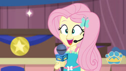 Size: 3410x1920 | Tagged: safe, screencap, fluttershy, best in show: the victory lap, equestria girls, g4, my little pony equestria girls: better together, best in show logo, cute, female, geode of fauna, hairpin, jewelry, magical geodes, microphone, necklace, open mouth, shyabetes, smiling, solo